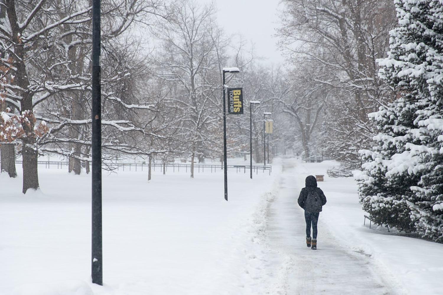 Student walking on CU Boulder campus in the snow