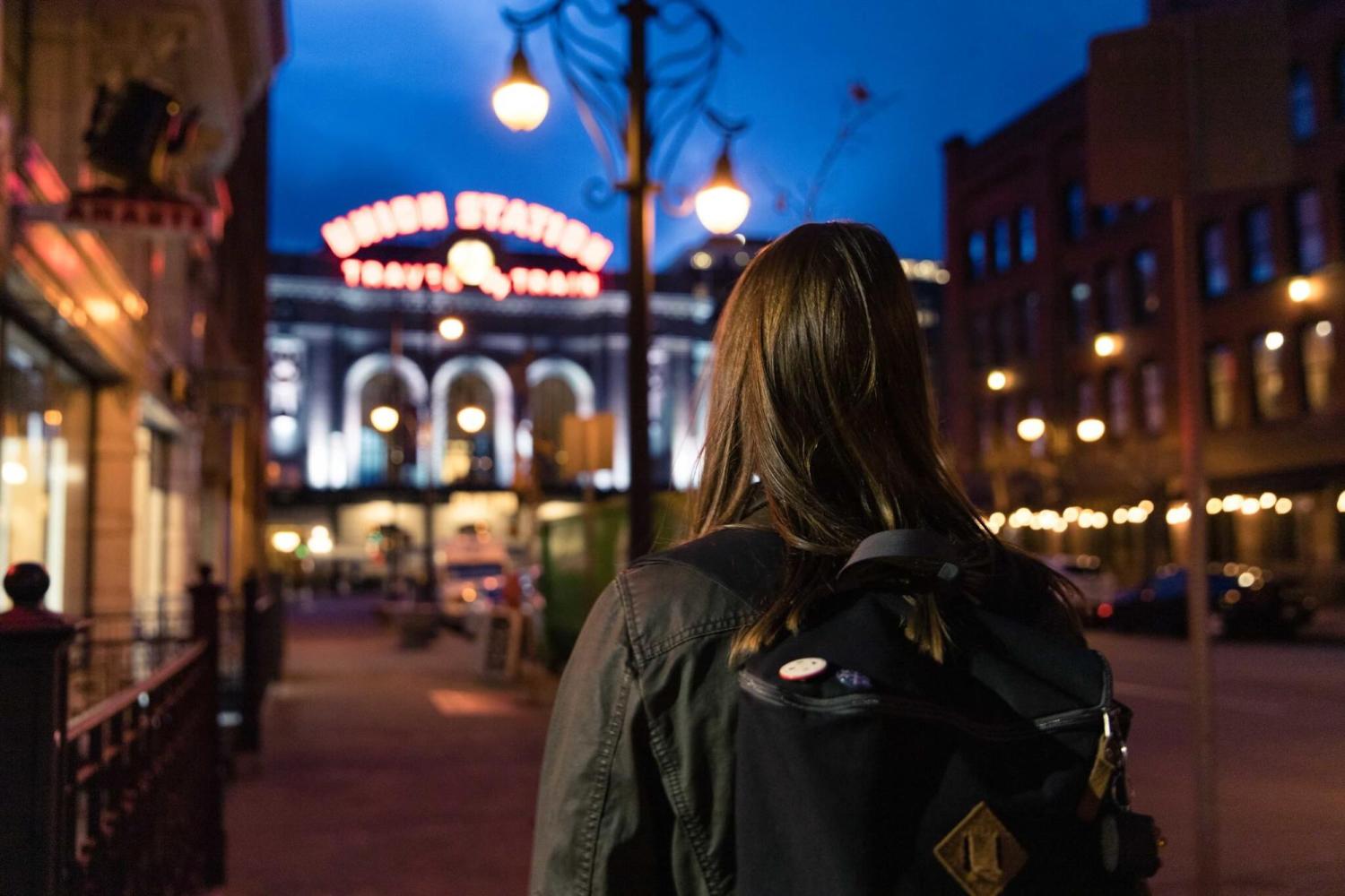 A young woman walks toward Union Station in downtown Denver in the late evening