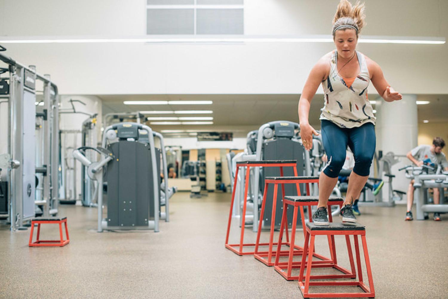 Photo of female athlete jumping on red and black stands